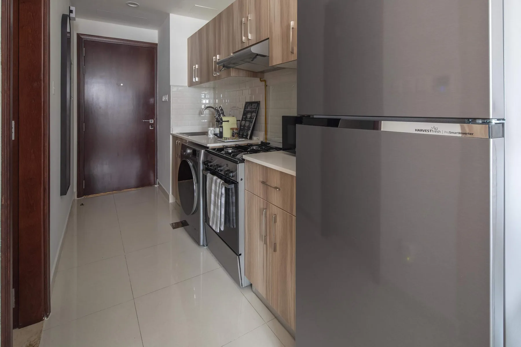 Una cocina compacta con gabinetes de madera, una estufa y un refrigerador.