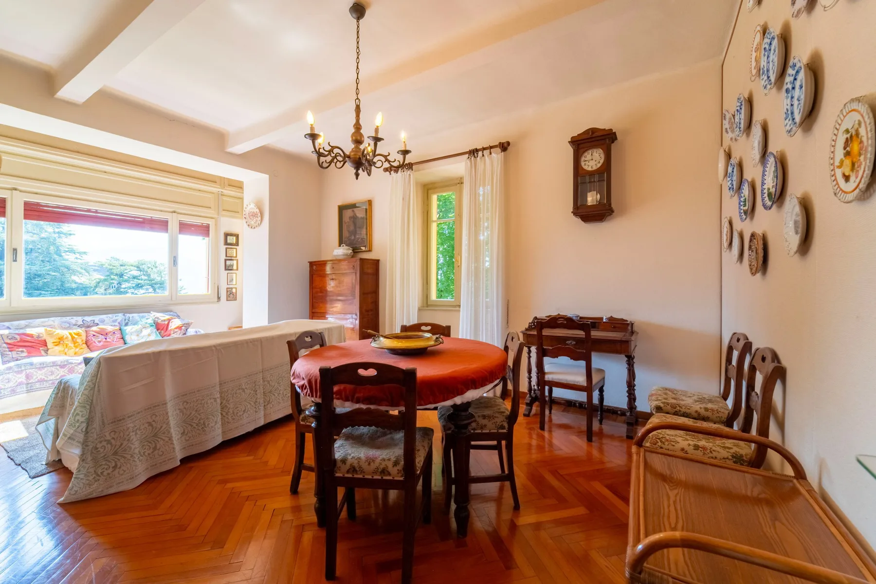 A dining room with a round table and chairs beside a large window.
