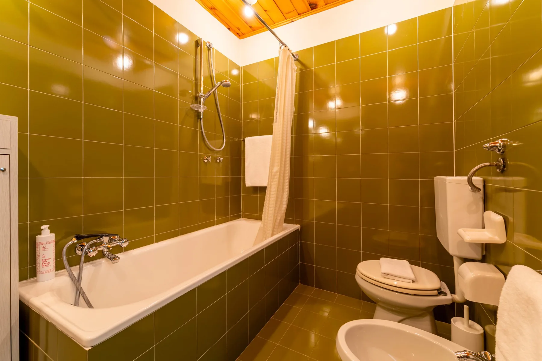 A tiled bathroom with a bathtub, shower, and toilet.