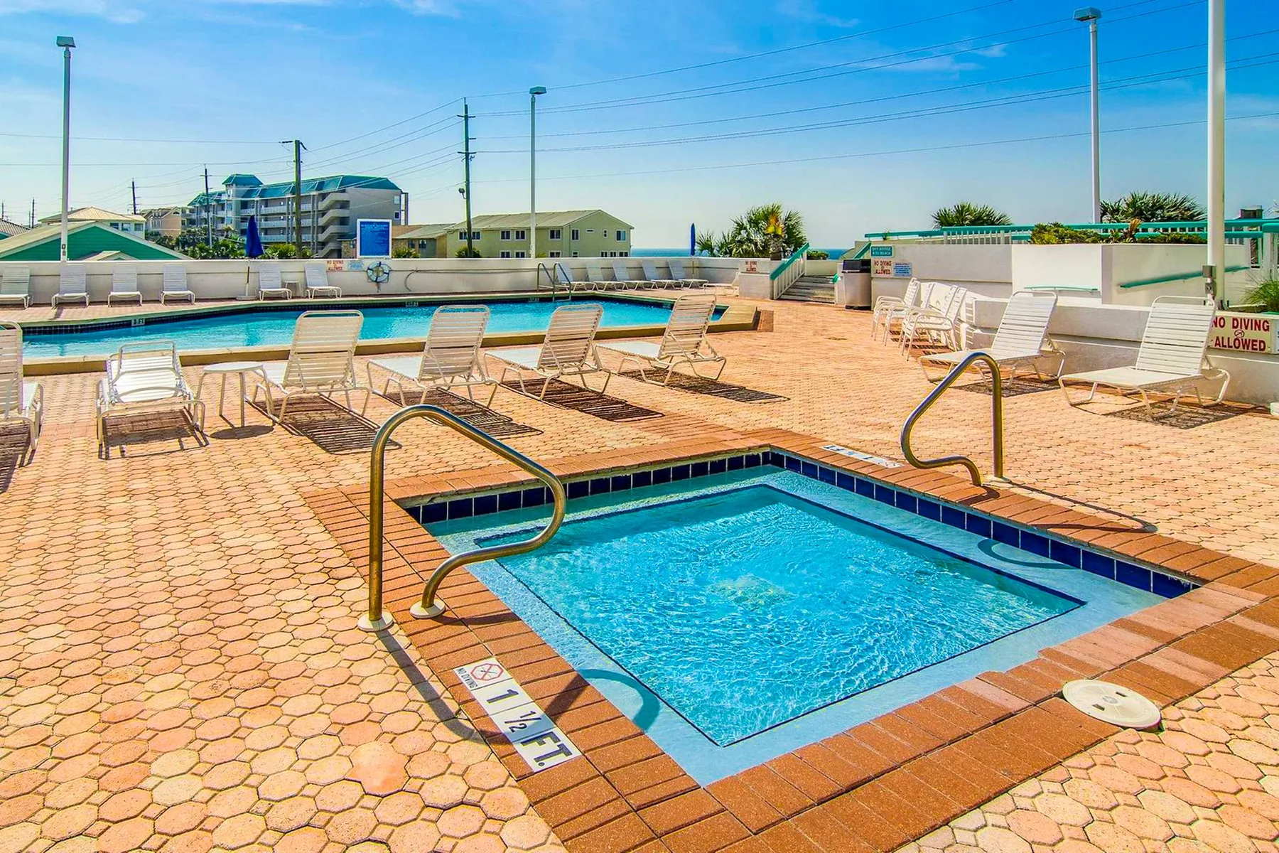 Zona de piscina al aire libre con una pequeña piscina cuadrada en primer plano.