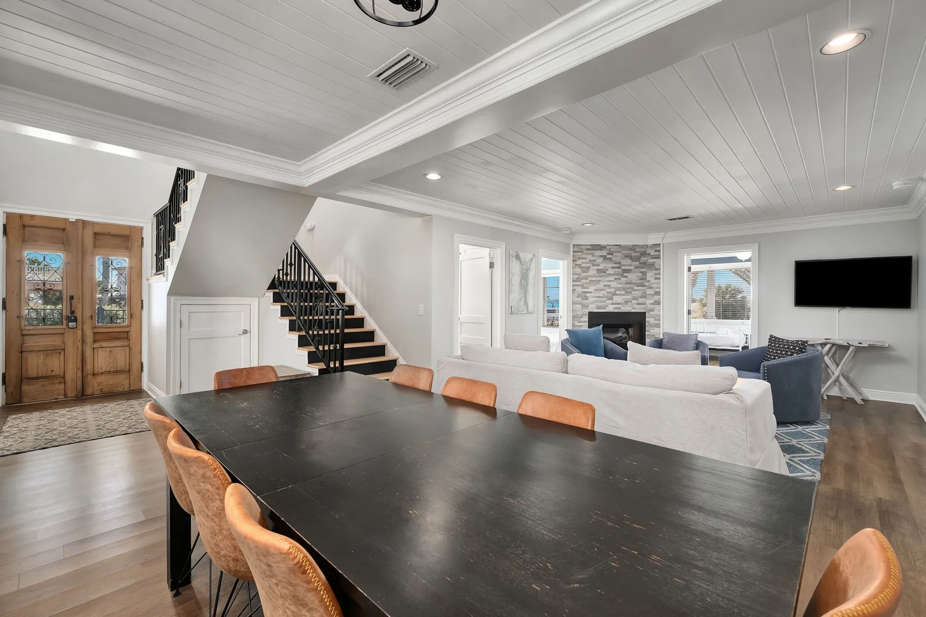 An open-plan living and dining area with a long dark table and seating.