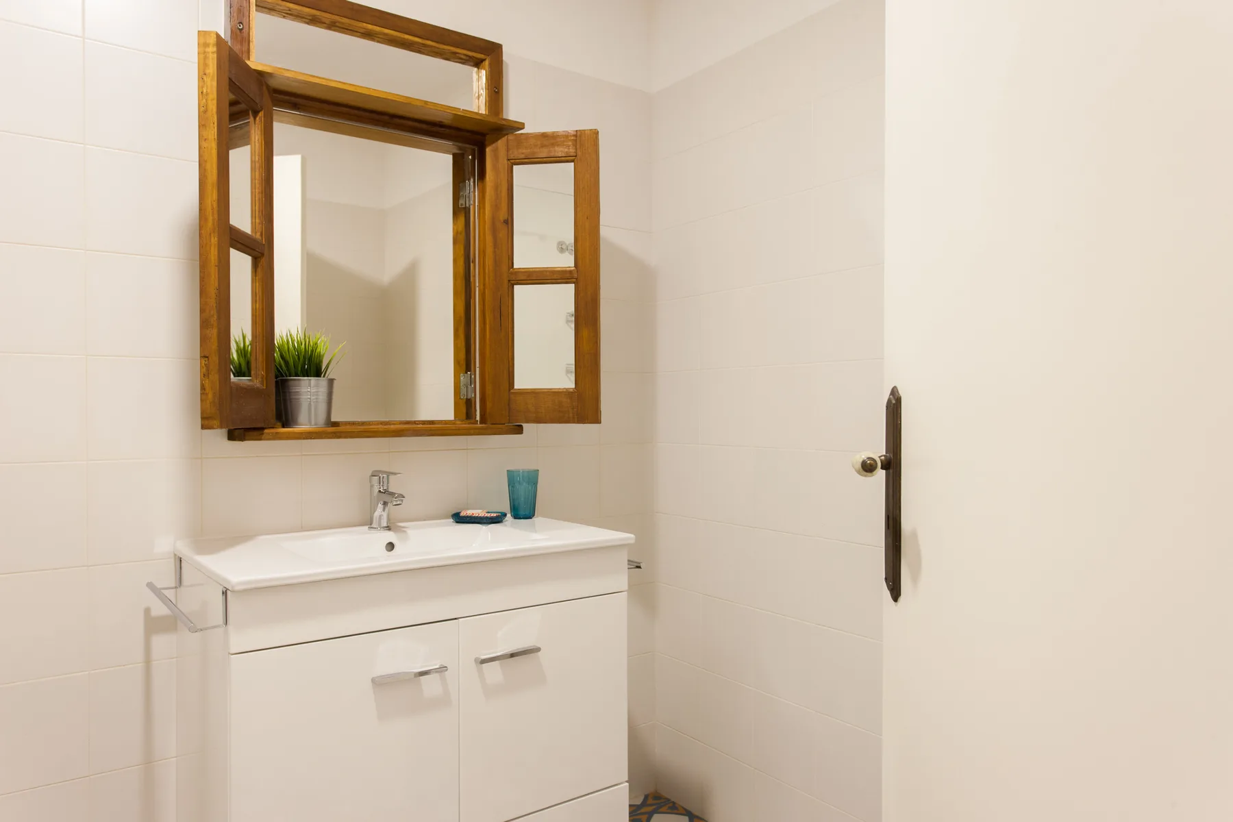 Un lavabo de baño con espejo de marco de madera.
