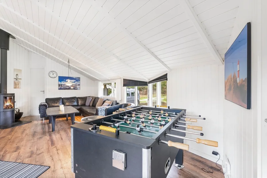 Una sala de estar luminosa con futbolín y asientos.