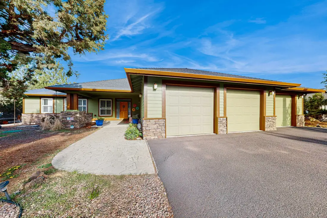 A single-story home with a paved driveway and attached garage doors.