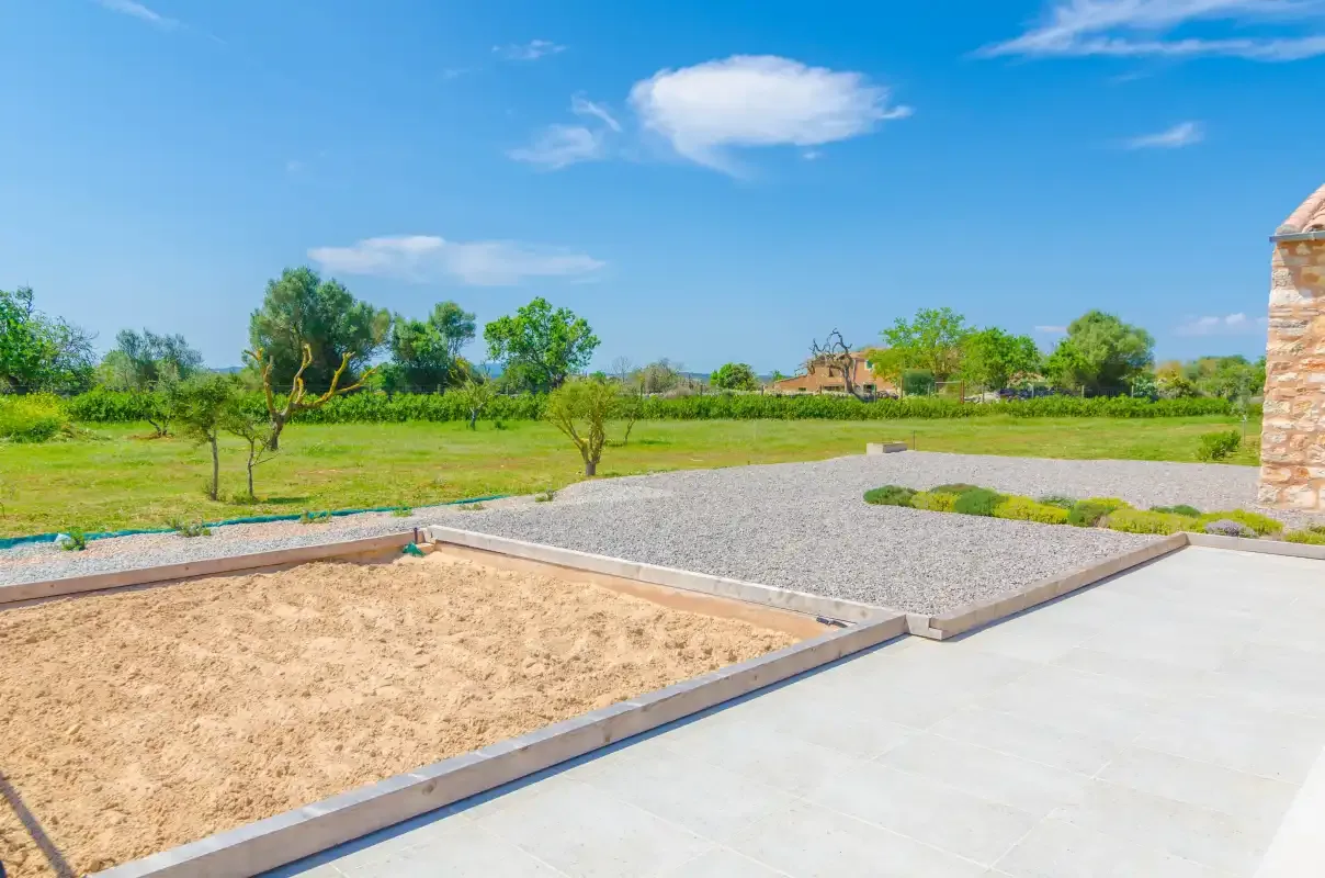 An outdoor patio overlooks gravel landscaping and a grassy yard.