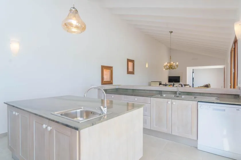 A bright kitchen with a foreground island and a long counter.