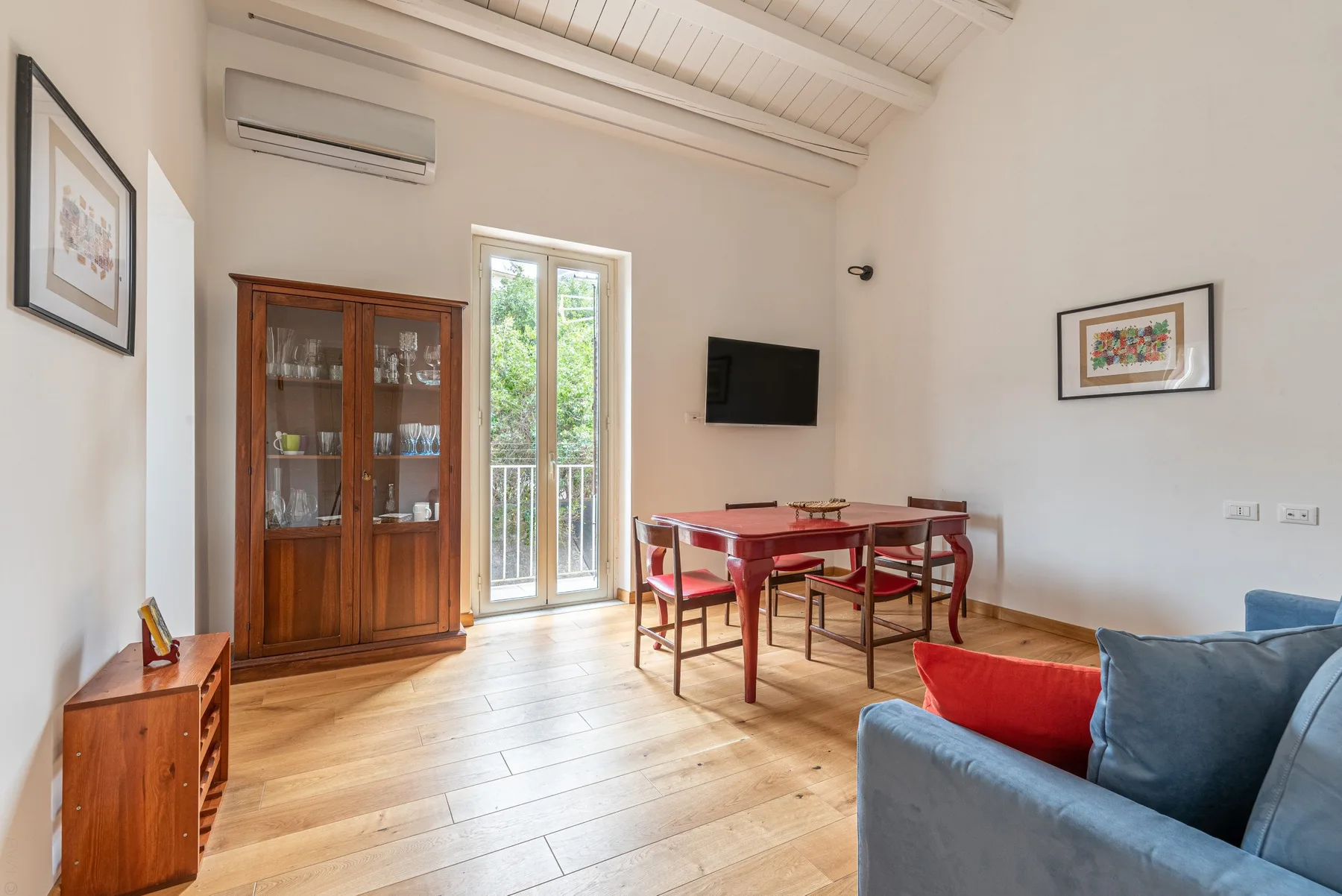 Una luminosa sala de estar y comedor con una mesa de madera y asientos azules.