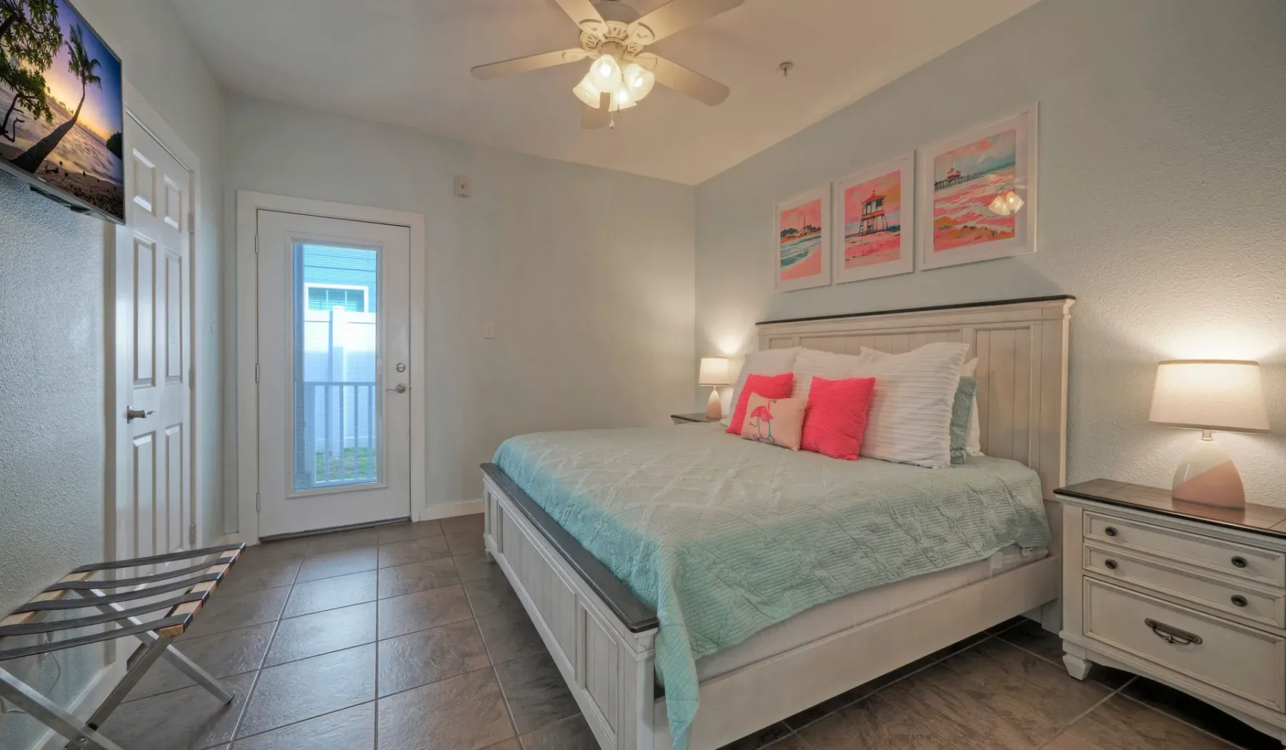 Un dormitorio con cama, mesitas de noche y una puerta con panel de vidrio.