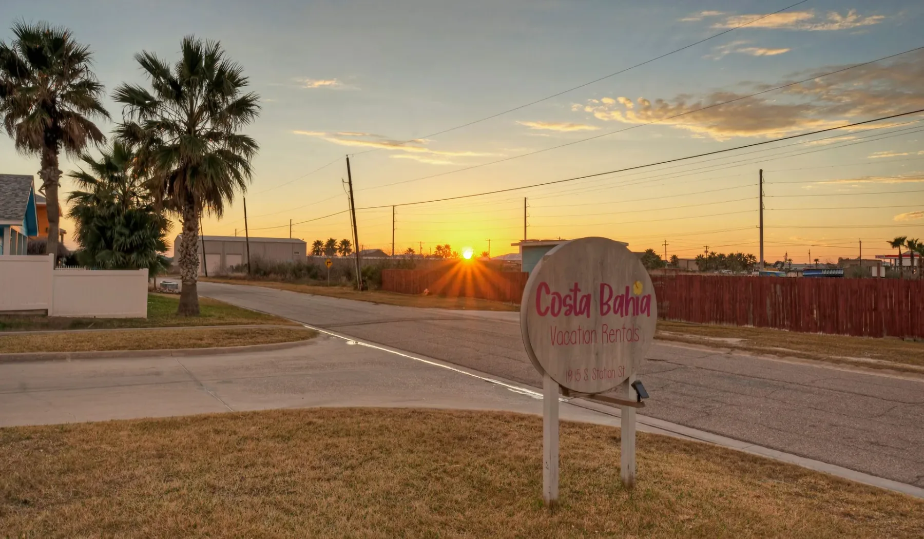 Un letrero junto a una calle al atardecer.