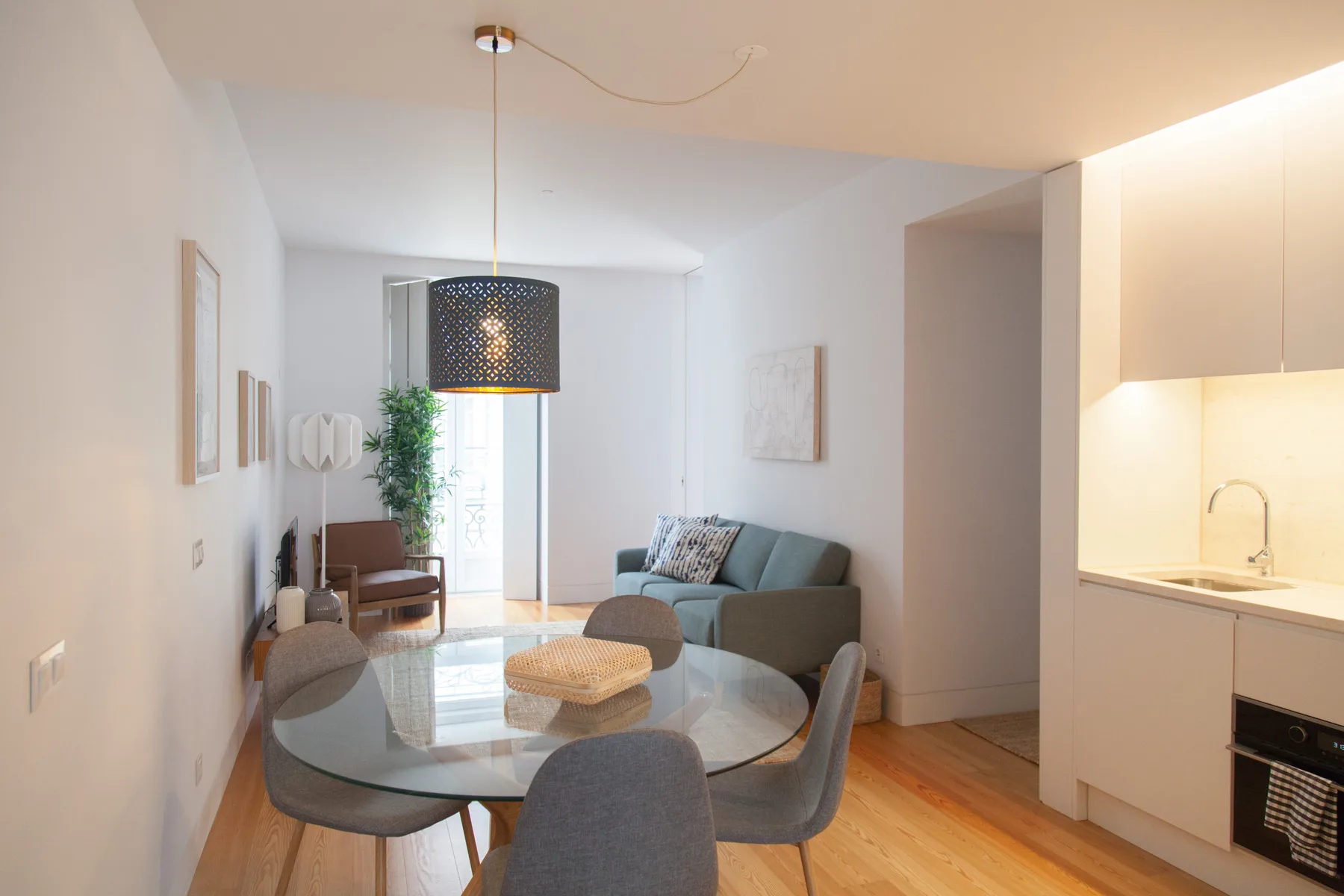 Una luminosa sala de estar y comedor con asientos junto a una cocina abierta.