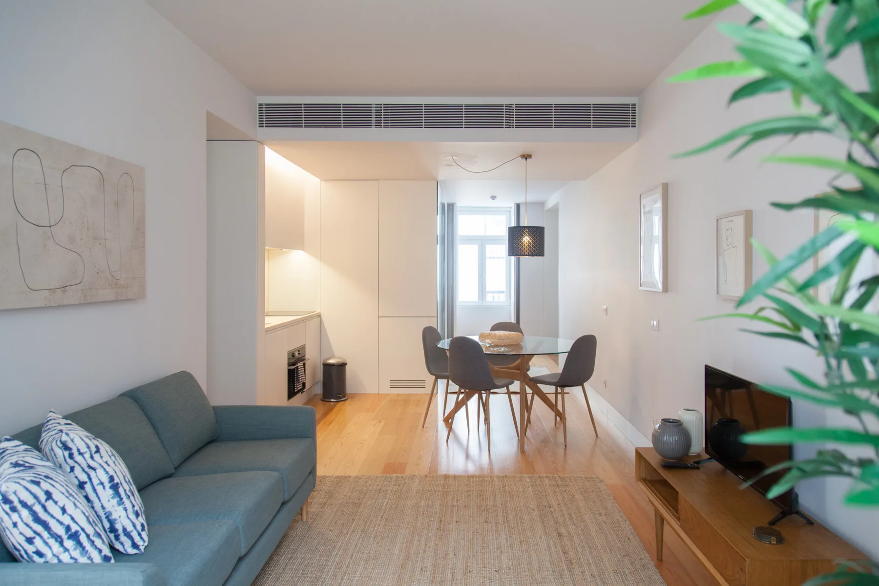 Sala de estar y comedor con sofá, mesa de comedor y sillas.