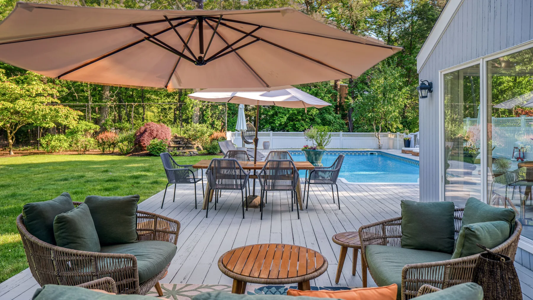 A patio seating area with a dining table beside a swimming pool.