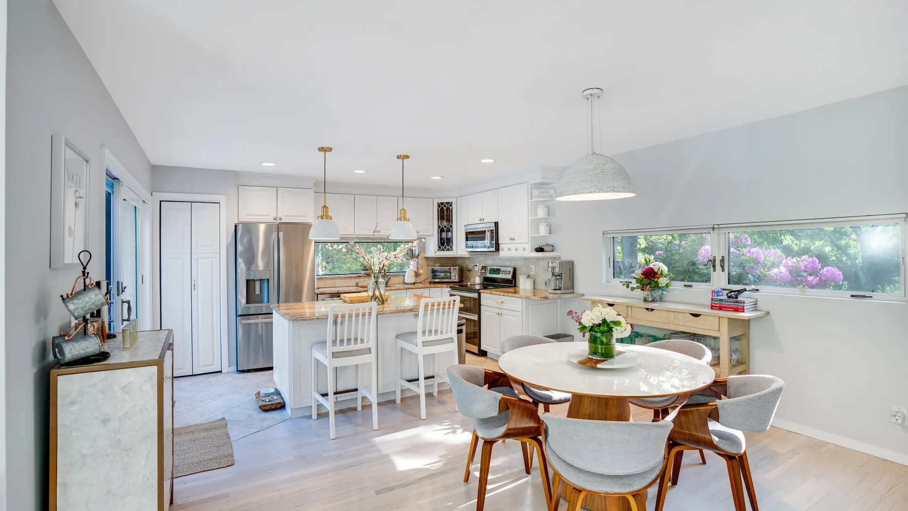 A bright kitchen and dining area with a central island and a round table.