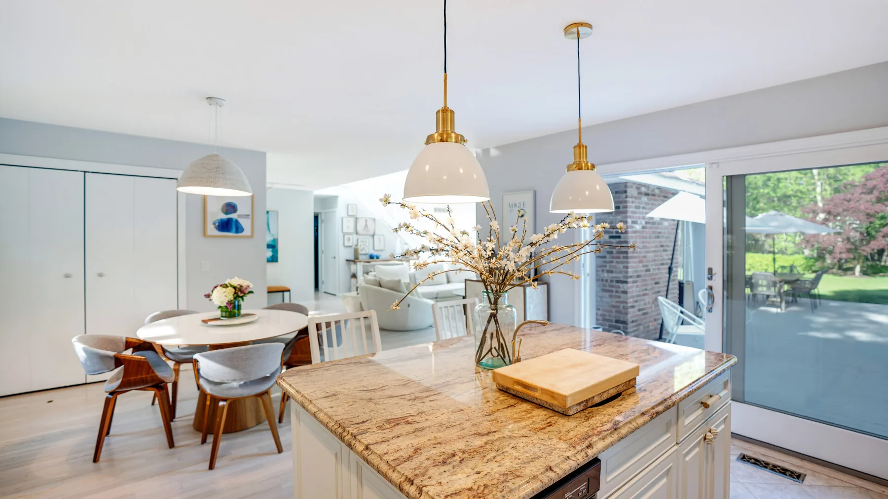 An open-plan kitchen and dining area with a large stone island and a dining table.