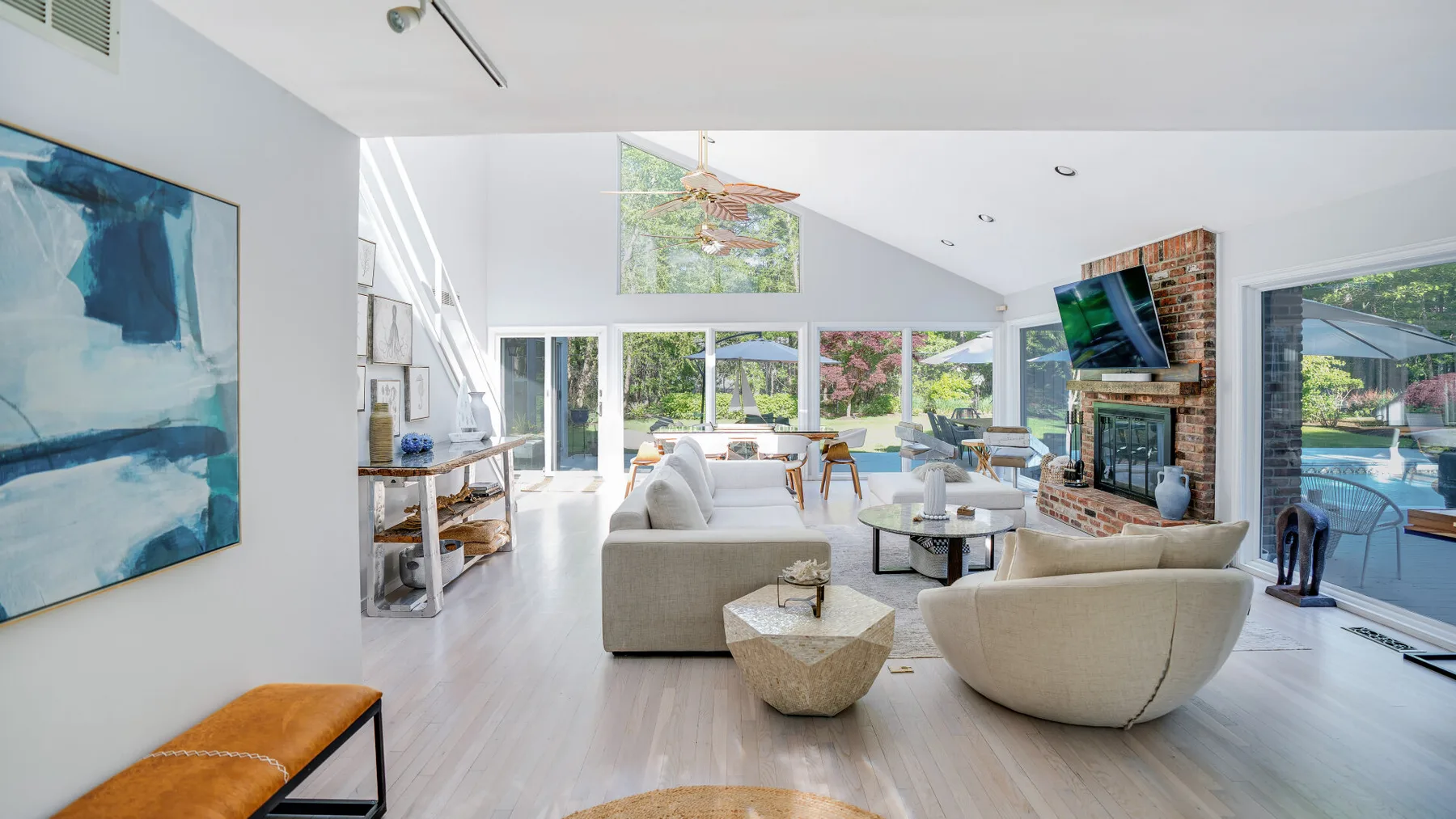 A bright living room with seating, a coffee table, and large windows.