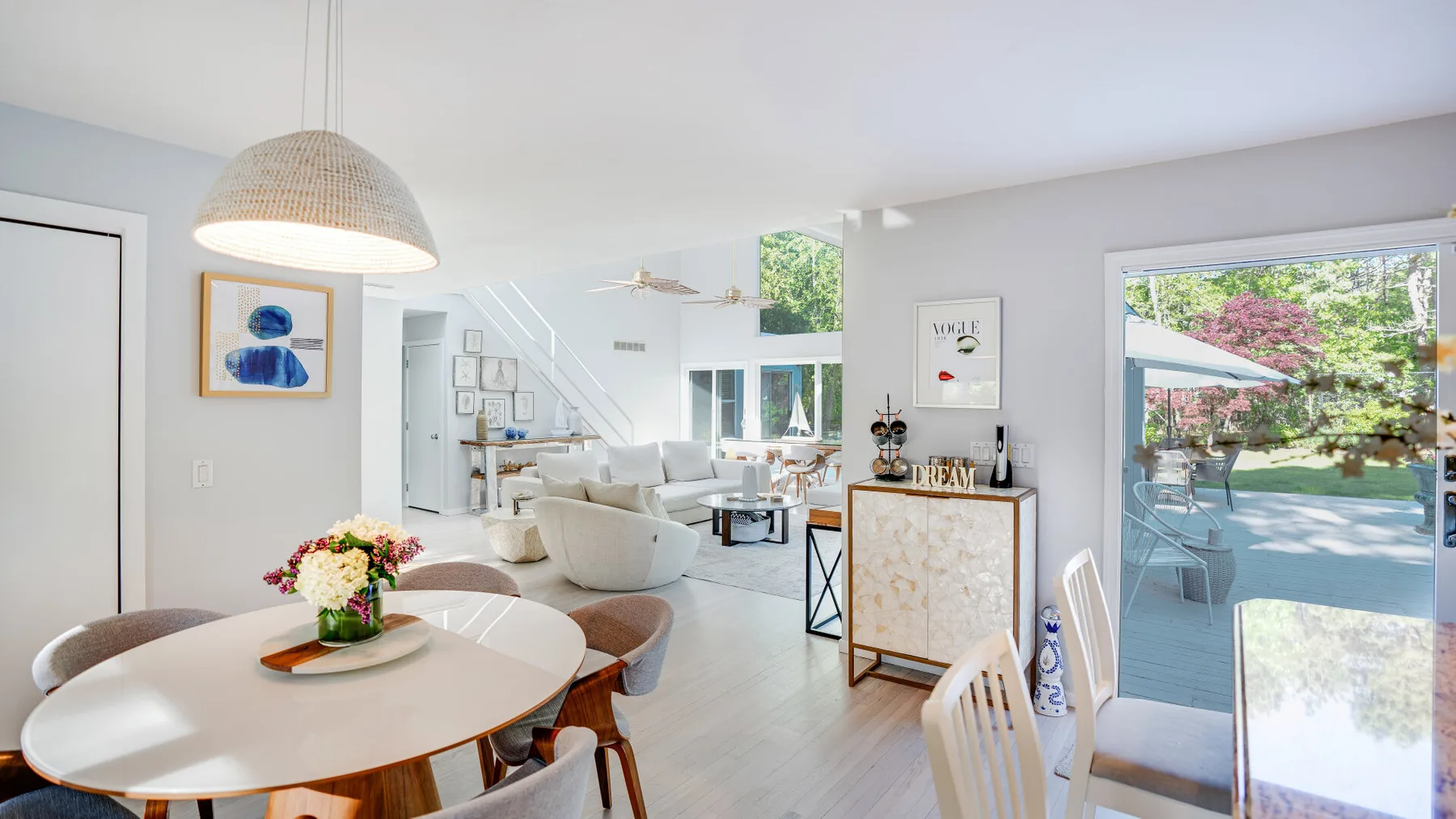 A bright open-plan living and dining area with large windows opening onto a garden.
