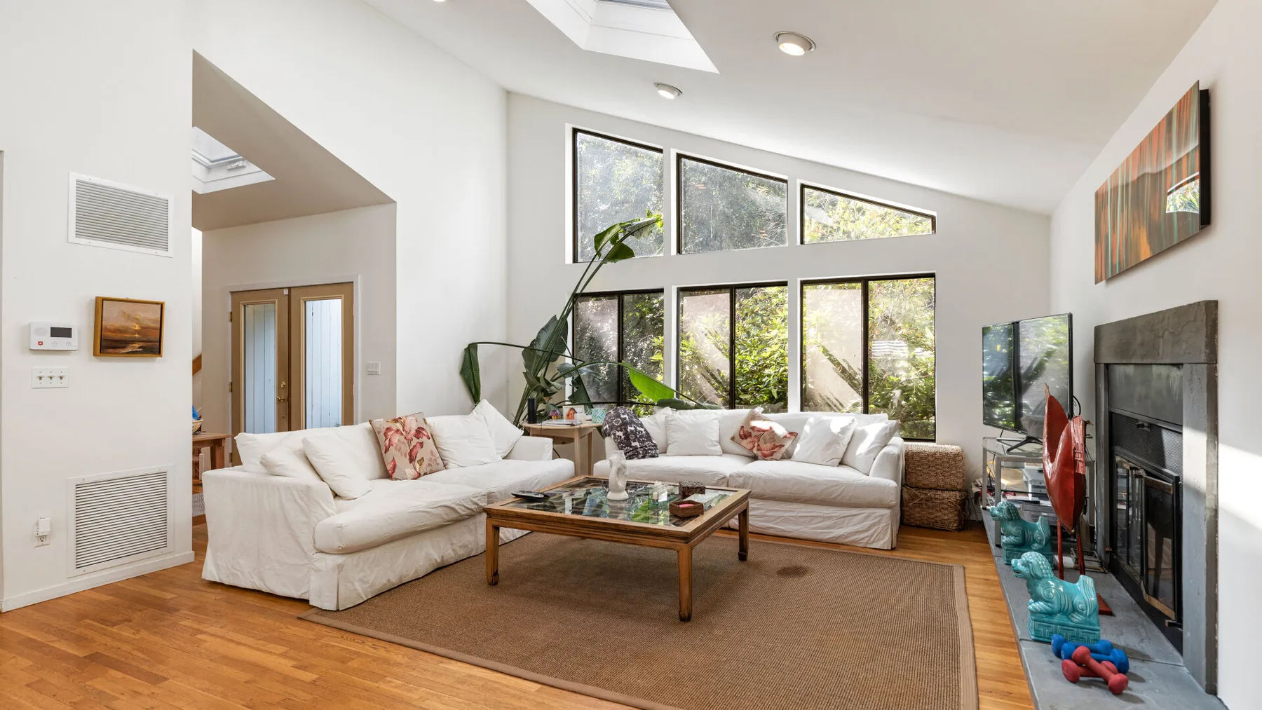 A bright living room with large windows, seating, and a coffee table.