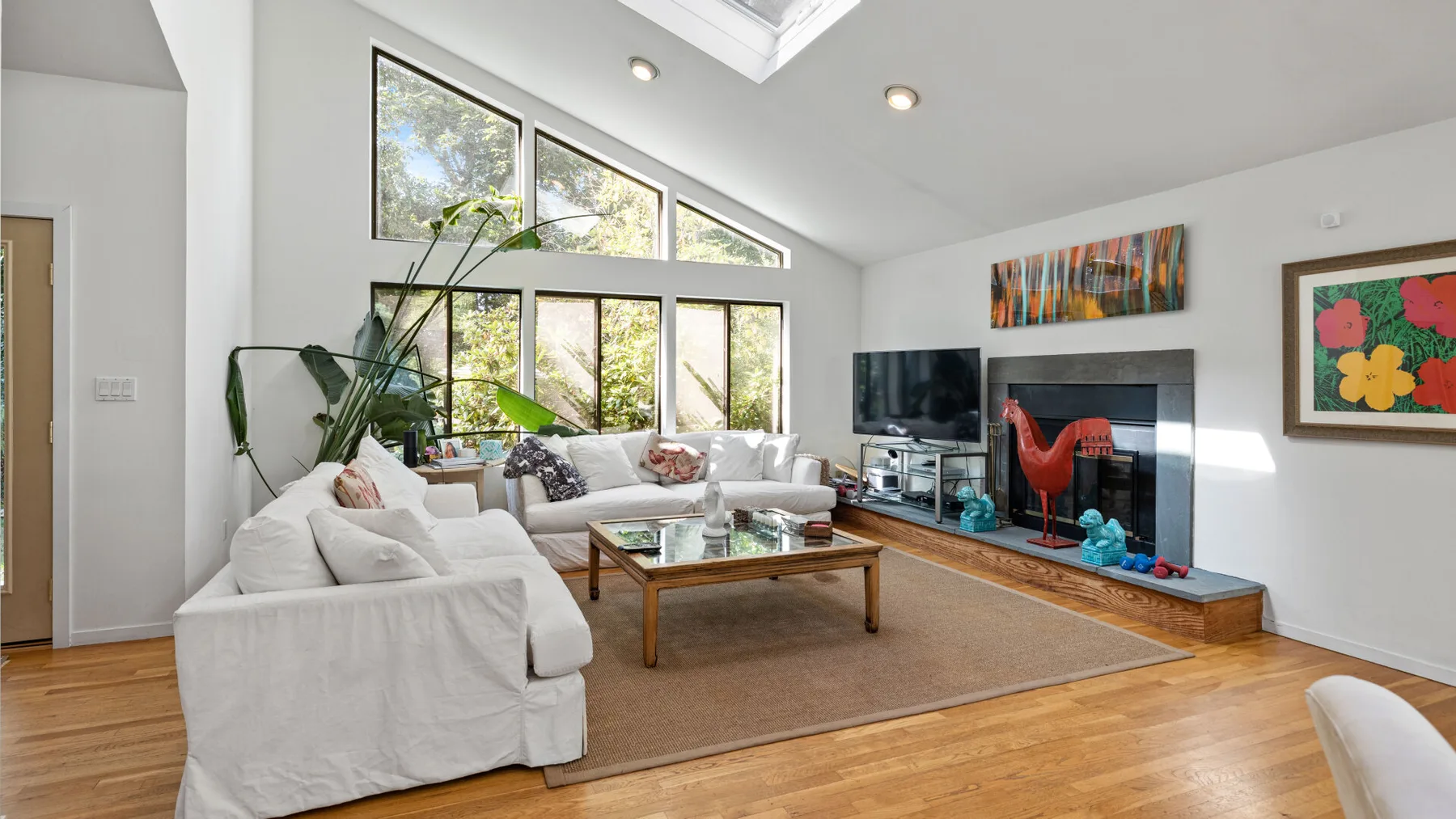 A bright living room with a seating area, coffee table, and large windows.