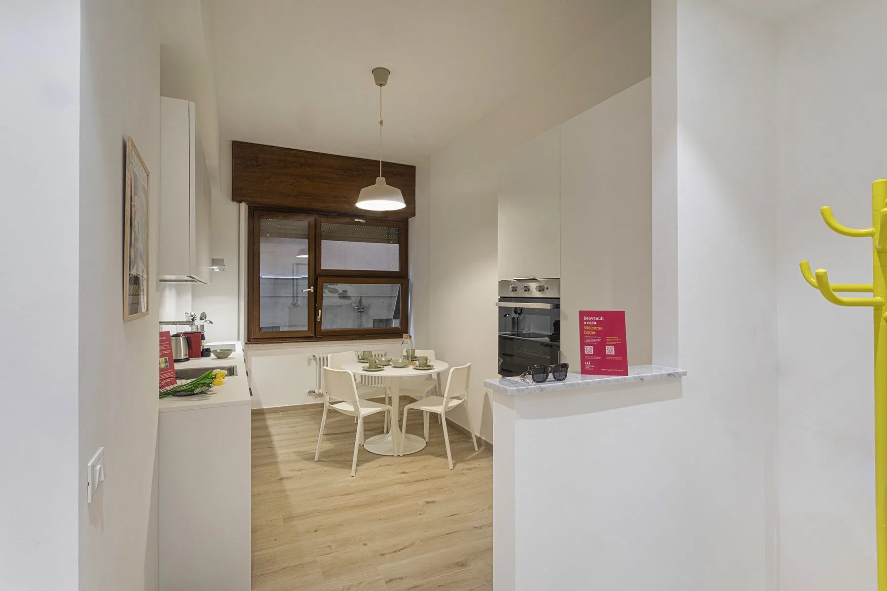 A bright kitchen and dining area with a table beside the window.
