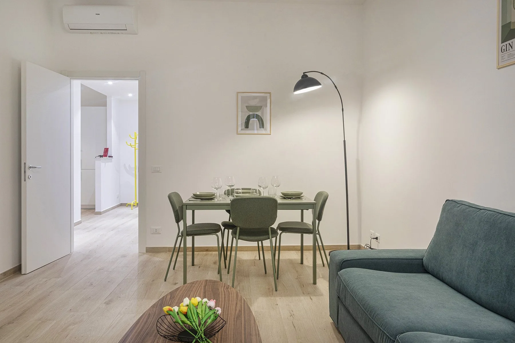 A dining area with a table and chairs beside a blue sofa.