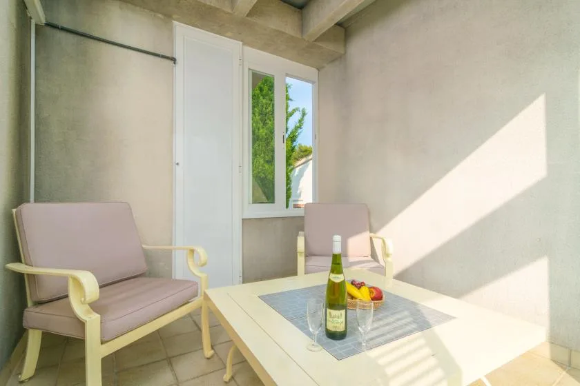 Una luminosa zona de estar con asientos acolchados alrededor de una mesa baja junto a una ventana.