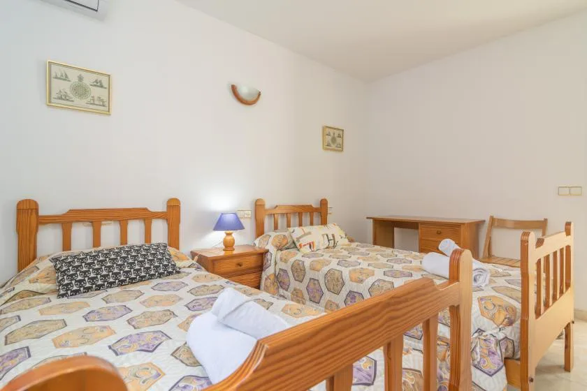 Un dormitorio con varias camas de madera y ropa de cama estampada.