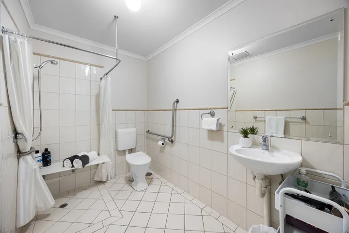 Un baño alicatado con ducha, inodoro y lavabo.