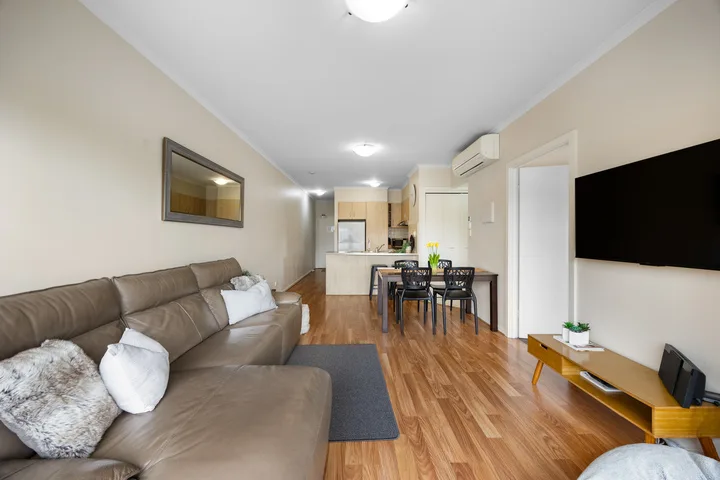 Una sala de estar con asientos, una mesa de comedor y una cocina abierta.