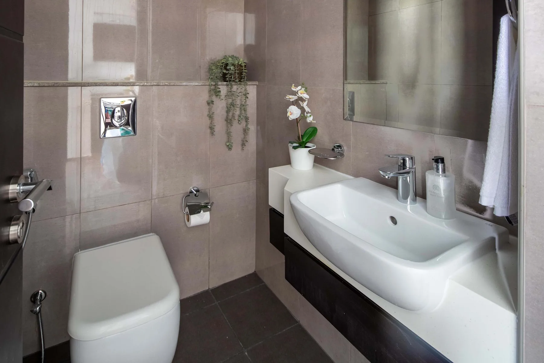 Un baño con lavabo, inodoro y una planta en maceta.
