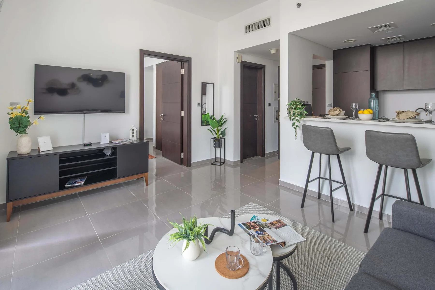 Una sala de estar moderna se conecta con una cocina con barra de desayuno.