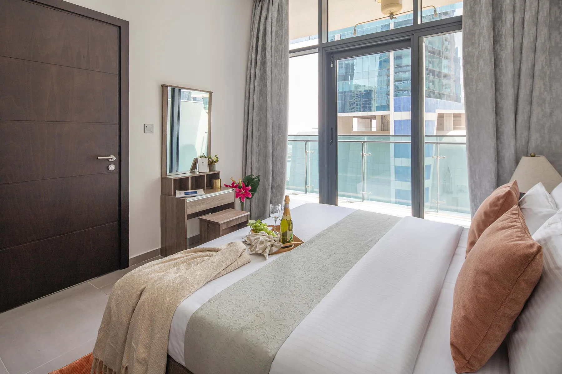 Un dormitorio con una cama arreglada junto a grandes puertas de vidrio.