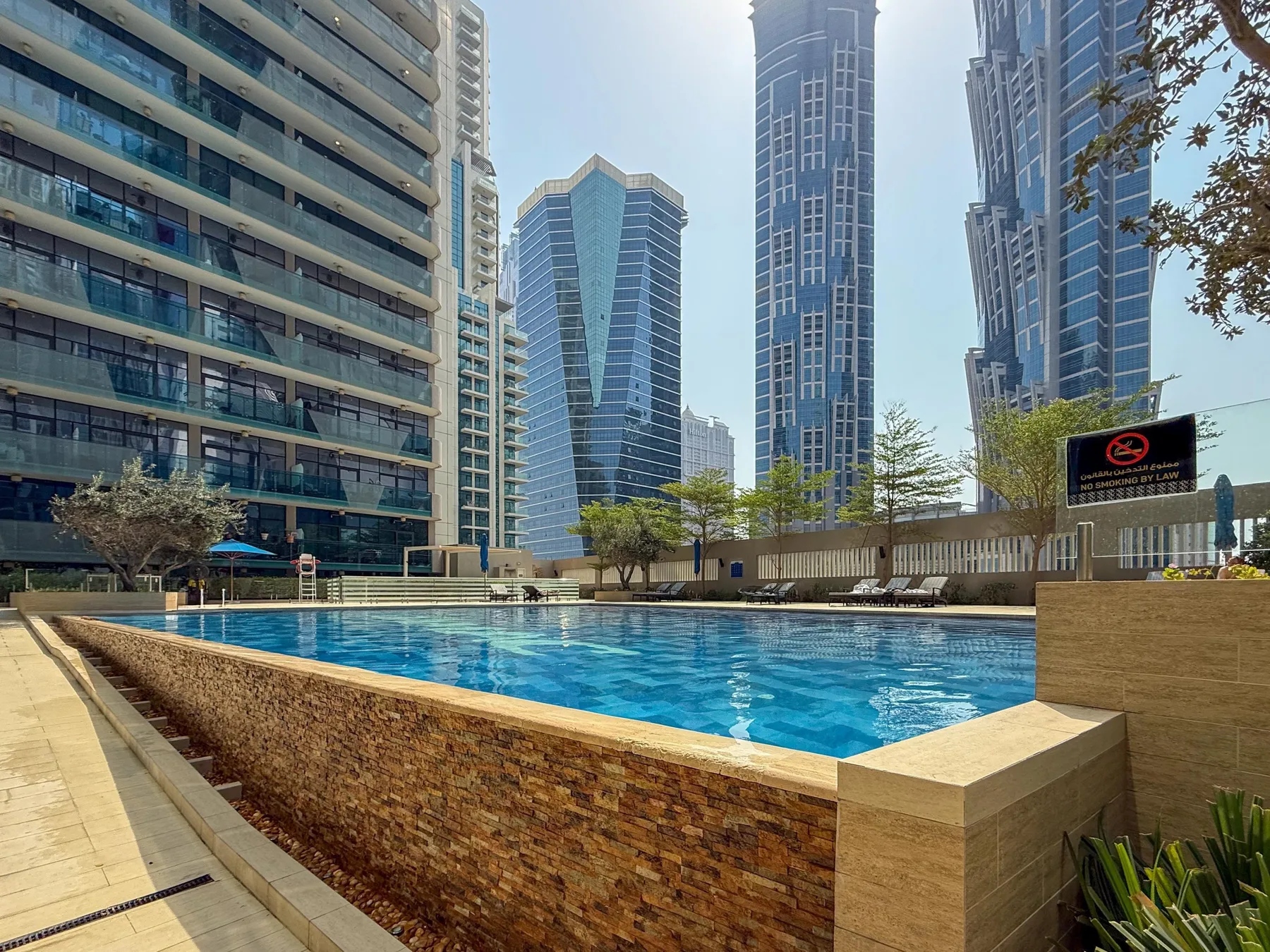 Una piscina al aire libre está rodeada de altos edificios residenciales modernos.