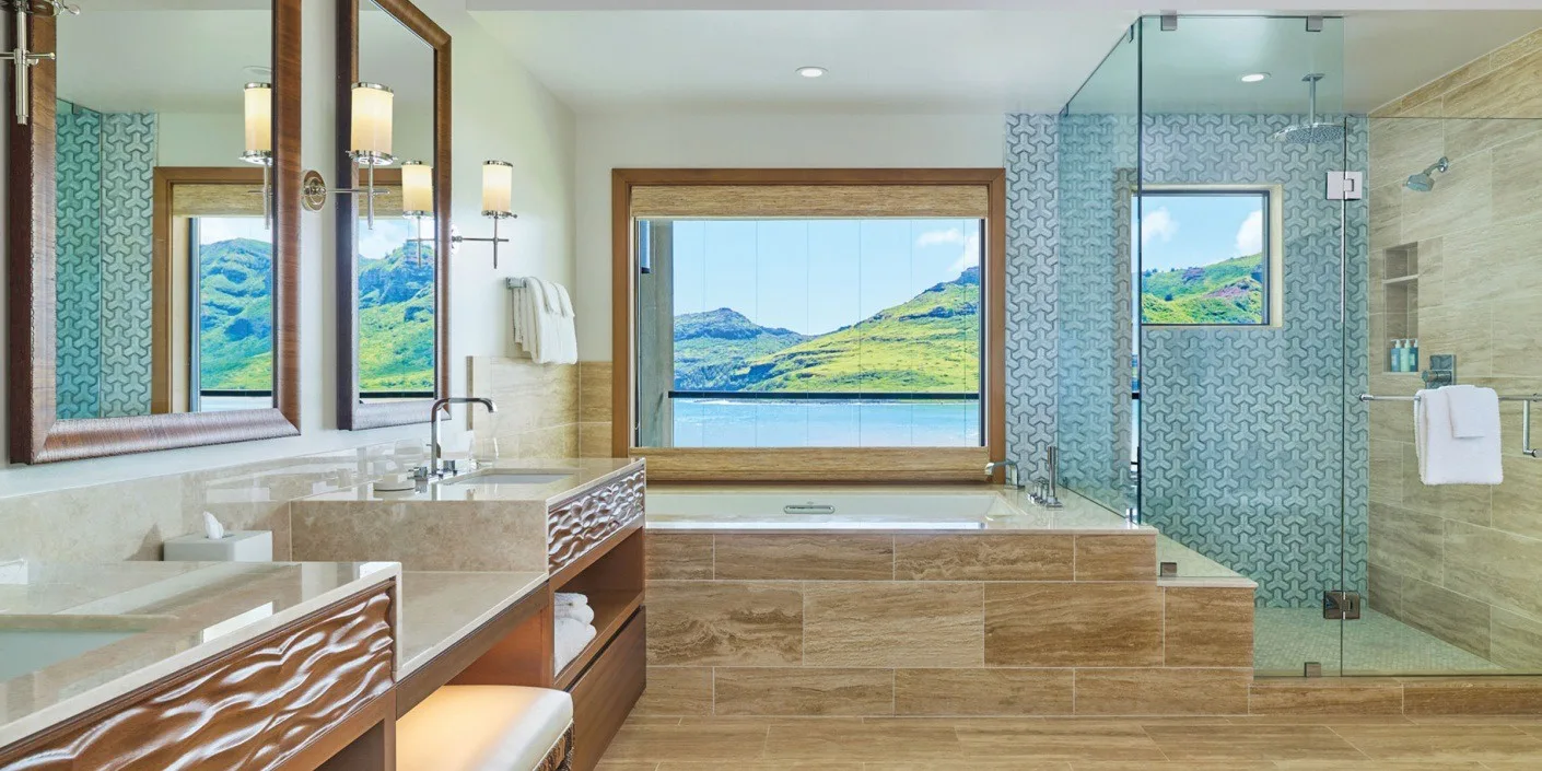 A bathroom with a large window overlooking a lake and a glass shower.