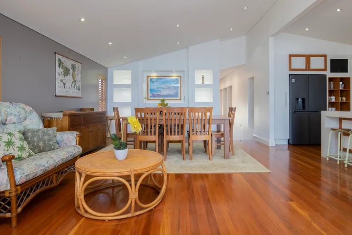 Una luminosa sala de estar y comedor diáfana con una mesa de madera y asientos.