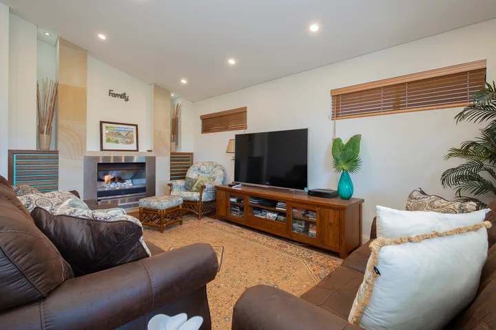 Sala de estar con asientos, una chimenea y un televisor.
