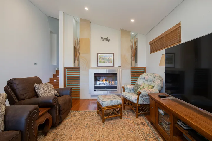 Una sala de estar con chimenea, asientos y un televisor.