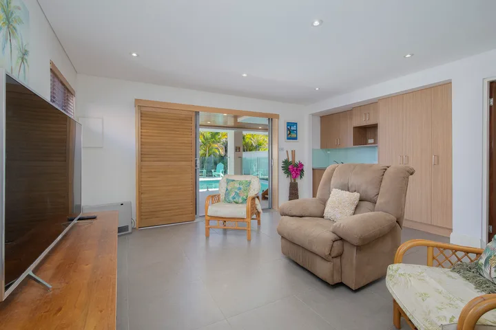 Una sala luminosa con un sillón reclinable y puertas corredizas de vidrio.