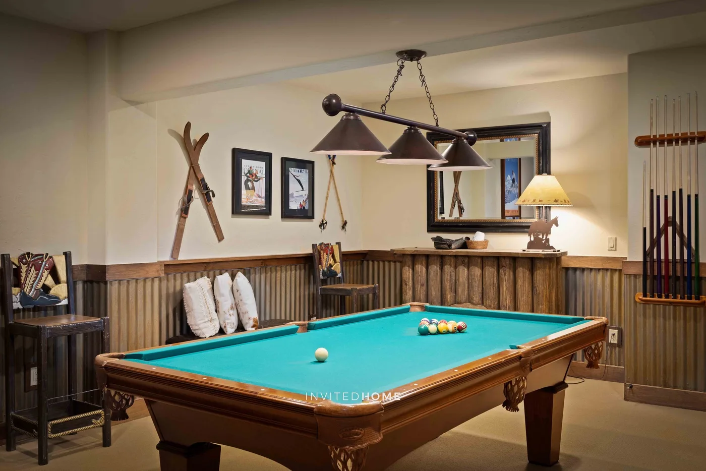 Una sala de recreación con una mesa de billar, decoración en las paredes y paneles de madera.