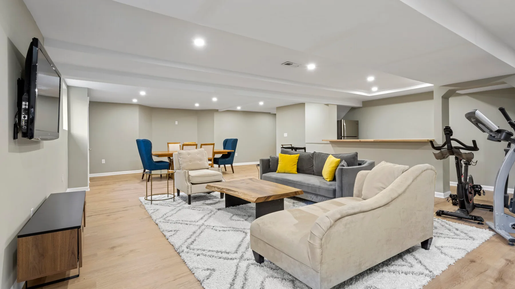 Una sala luminosa con asientos alrededor de una mesa de centro y un comedor al fondo.