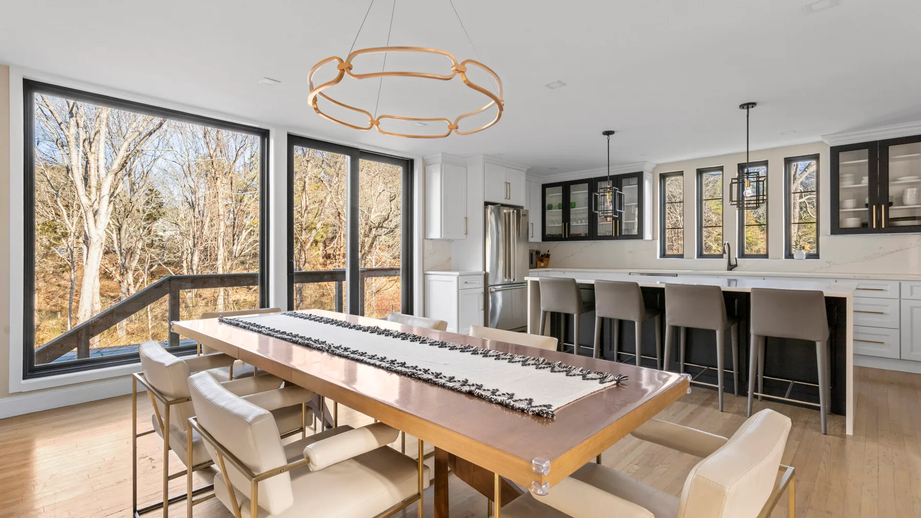 Una cocina luminosa con comedor cuenta con una mesa larga y ventanas amplias.