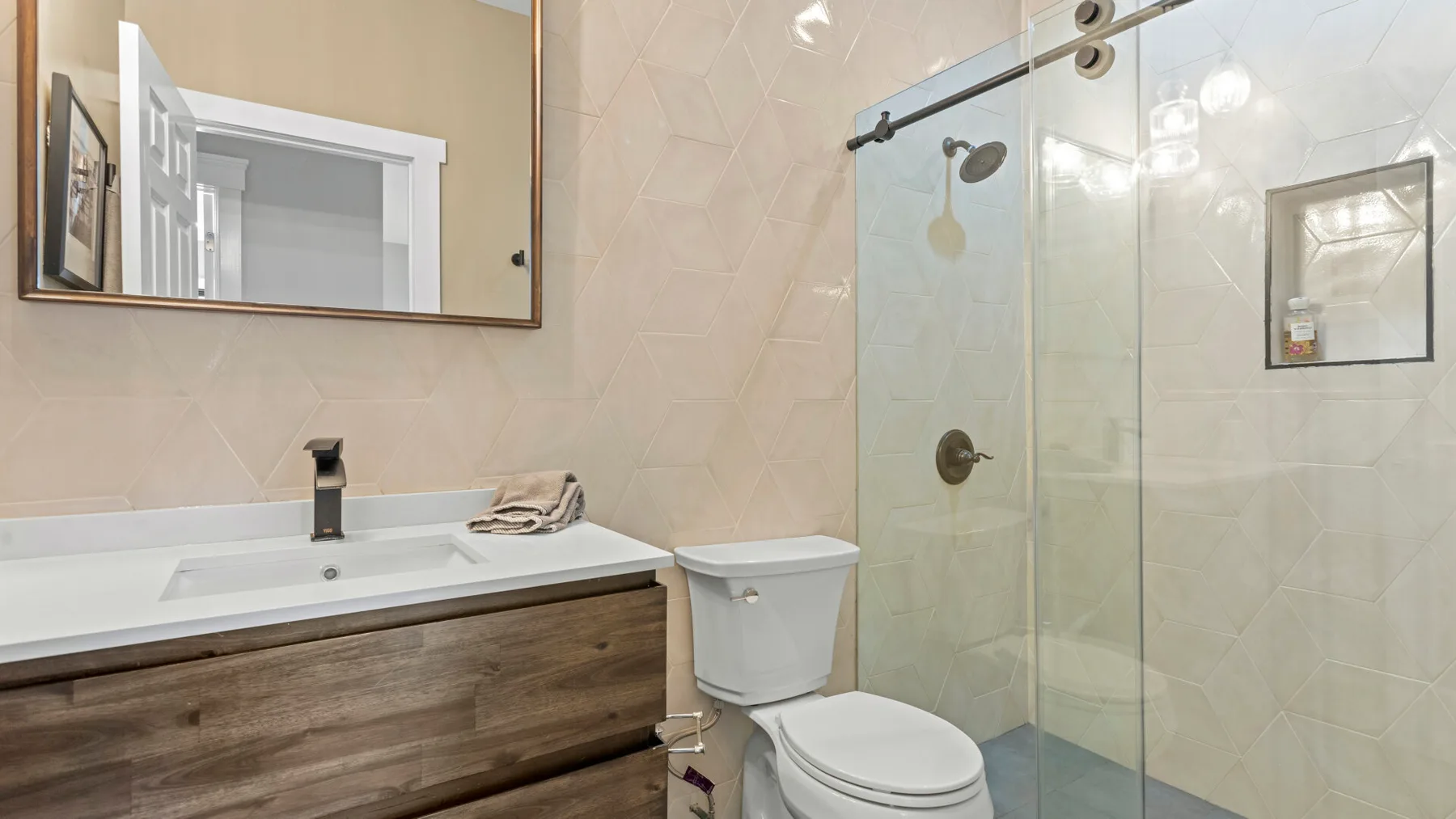 Un baño con lavabo, inodoro y ducha de vidrio.