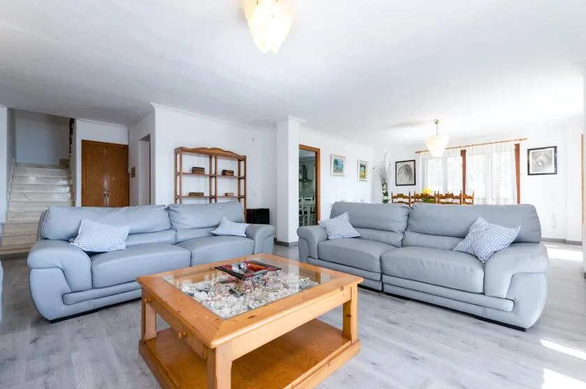 A bright living room with seating and a wooden coffee table.