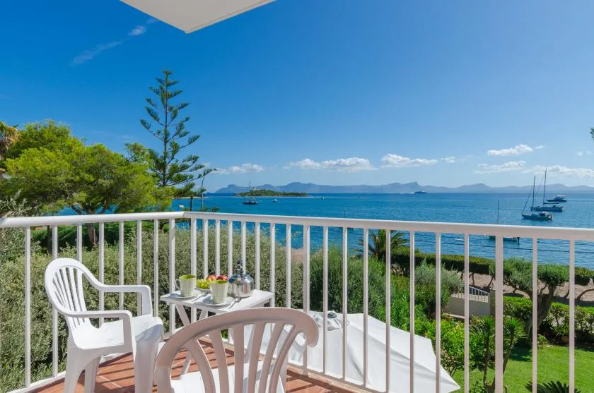 A balcony seating area overlooks the sea and distant islands.