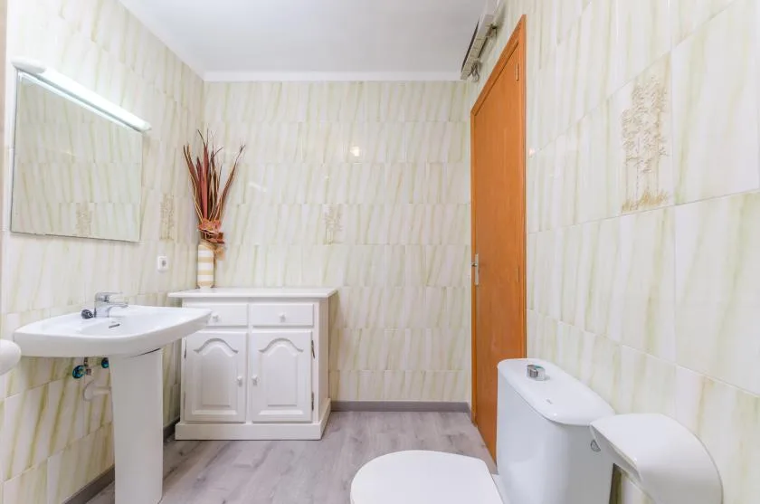 A tiled bathroom with a sink, vanity, and toilet.