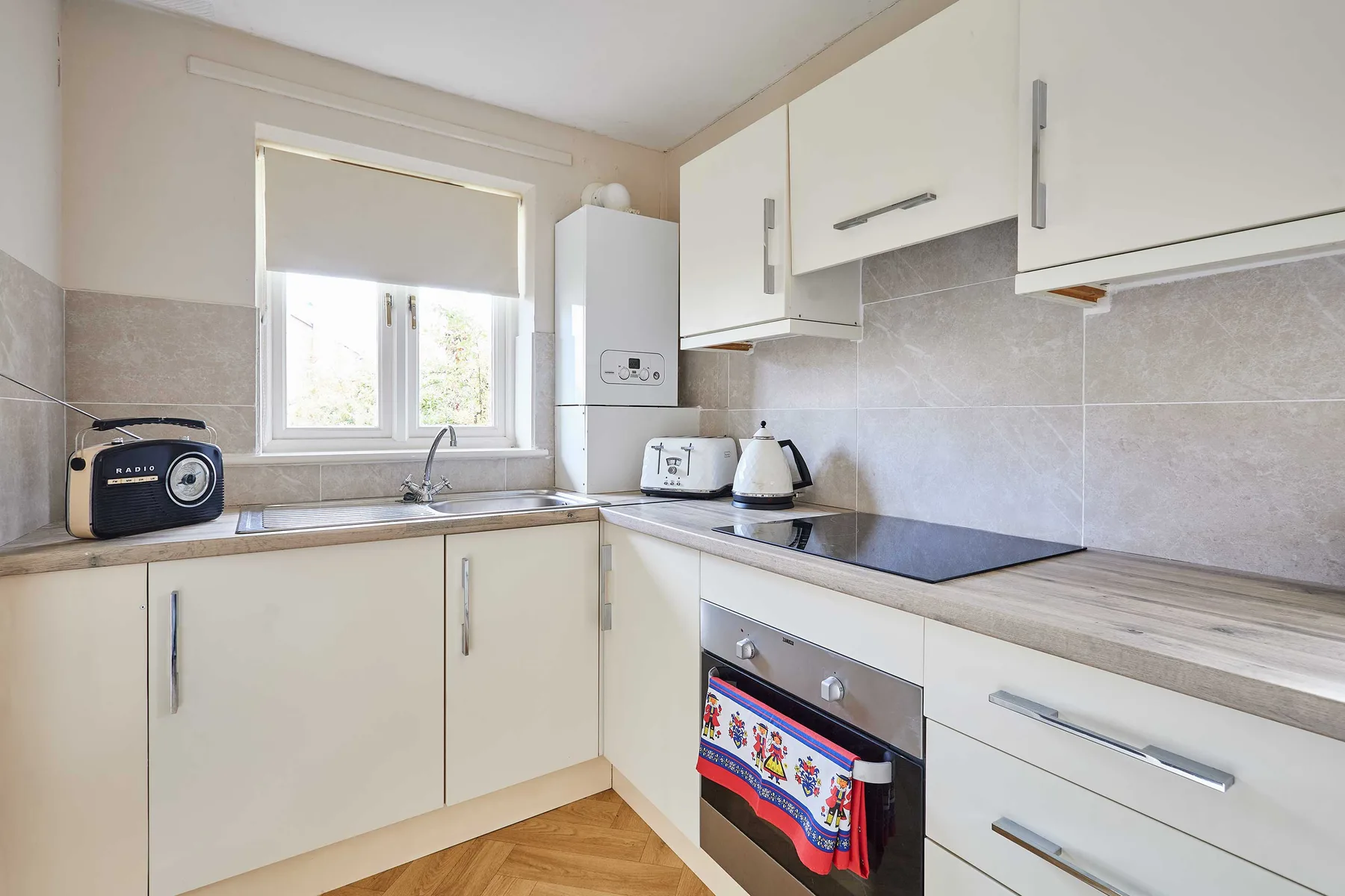 Una cocina luminosa con armarios blancos y una placa de cocina.