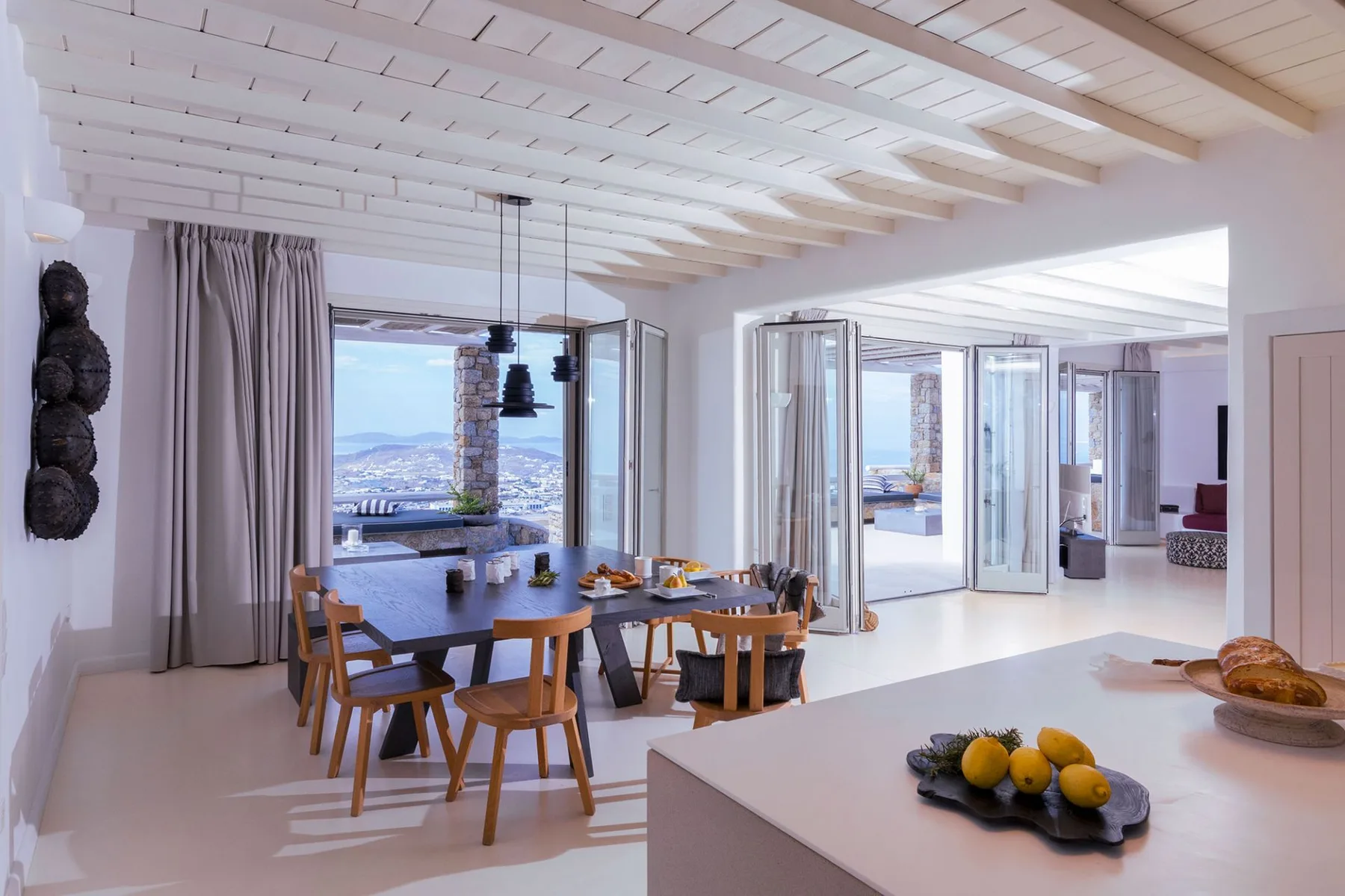 A bright dining area opens onto a terrace with views of the water.