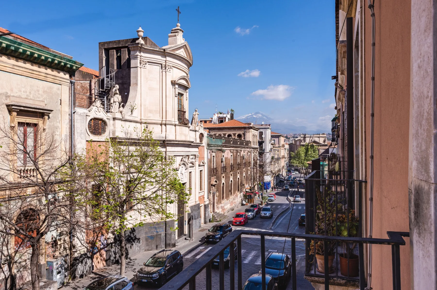 A city street lined with historic buildings, viewed from a balcony.