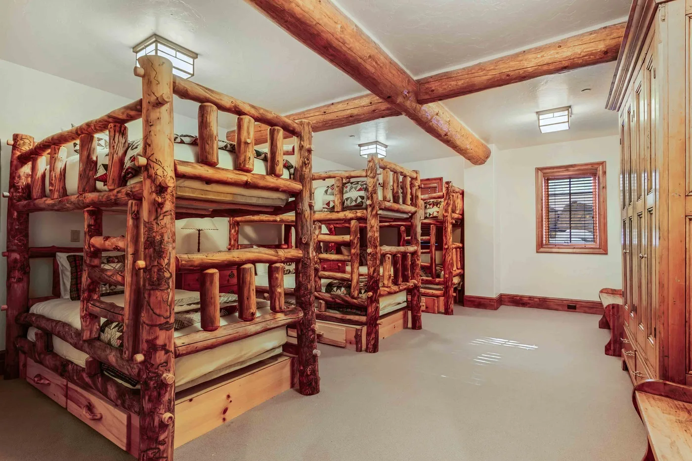 Un dormitorio con literas de madera rústica y una ventana.