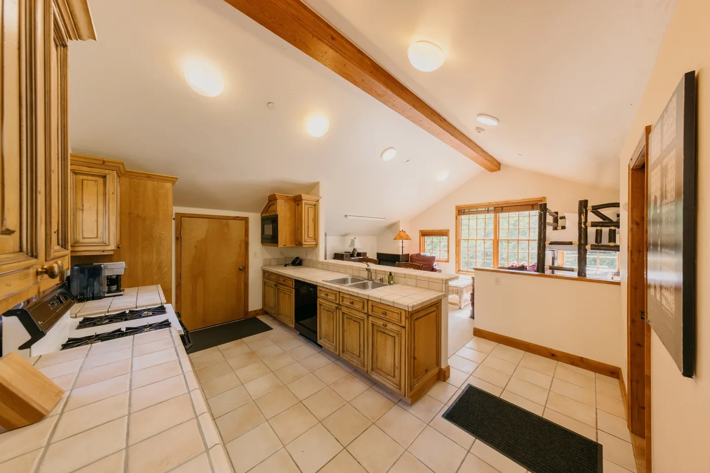 Una cocina amplia con gabinetes de madera, superficies de azulejo y una isla central.