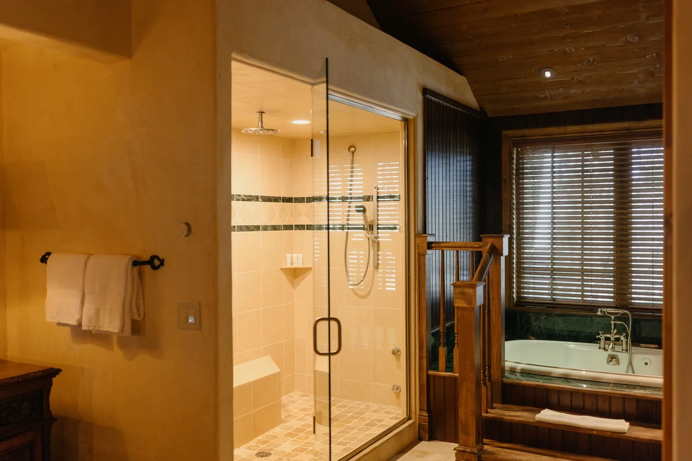 Un baño con una ducha de vidrio y una bañera junto a una ventana.